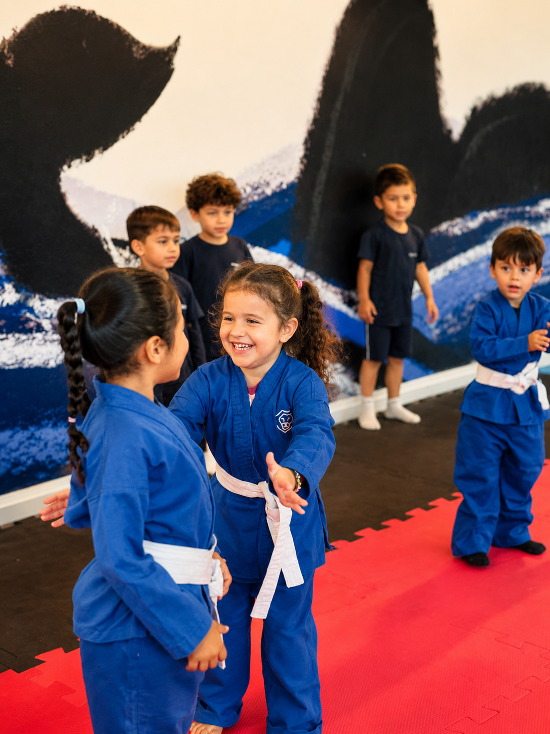 Crianças em aula de artes marciais no Theorema Bilingual School em Balneário Piçarras SC, desenvolvendo disciplina, coordenação motora, socialização e corporeidade em escola bilíngue premium.