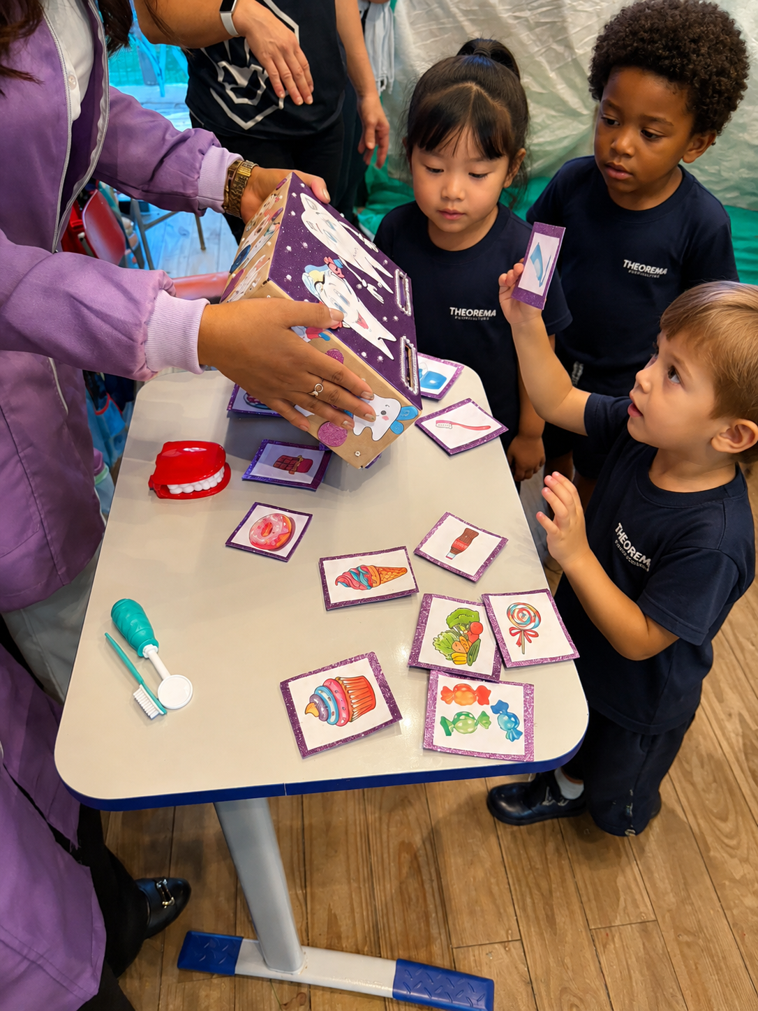 Crianças da educação infantil participando de atividade pedagógica interativa sobre saúde bucal e alimentação saudável na Theorema Bilingual School em Balneário Piçarras, com aprendizagem lúdica, desenvolvimento cognitivo e ensino bilíngue em ambiente acolhedor.